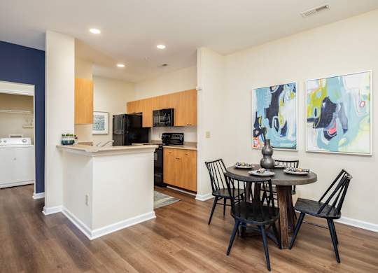 A kitchen with a dining table and chairs.