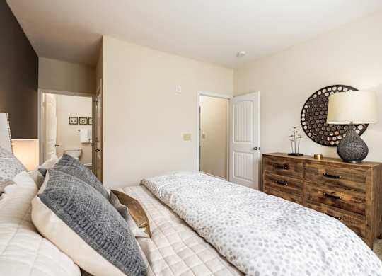 A bedroom with a bed, nightstand, and lamp.