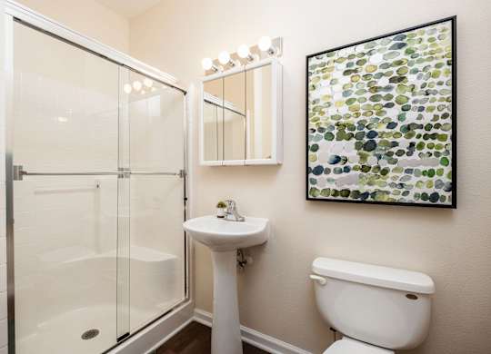 A bathroom with a toilet, sink, and shower.