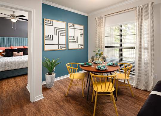 A dining room with a table set for four.