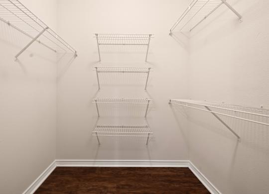 Empty room with white walls and brown floor.
