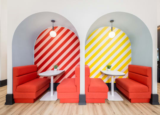 two orange chairs and tables in a room with two surfboards