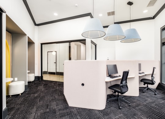 a large office area with desks and chairs and a partition
