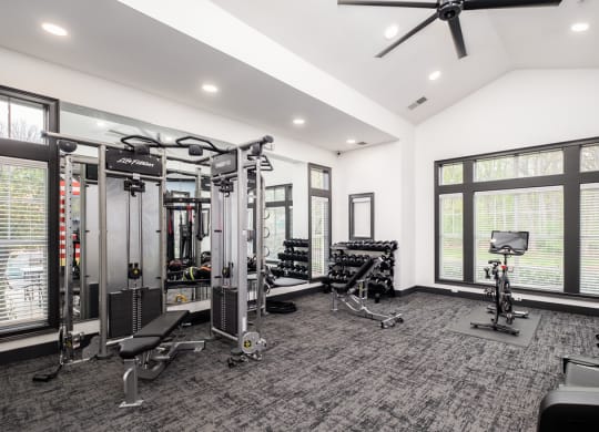 a home gym with weights and cardio equipment and large windows