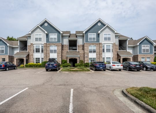 a large apartment building with a parking lot in front of it