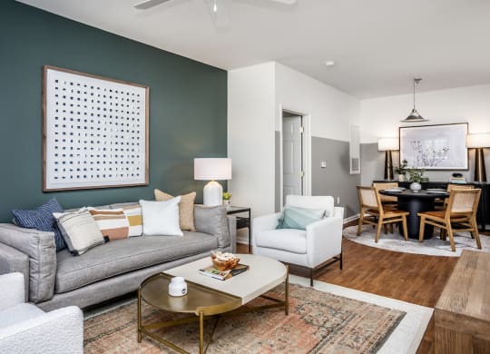 a living room and dining room with a couch and chairs and a table with a chair and