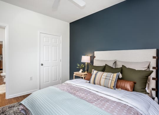 a bedroom with a bed and a nightstand with a lamp