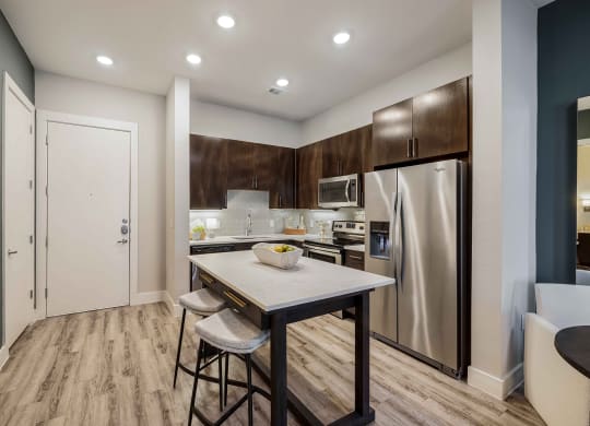 a kitchen with stainless steel appliances and a island with two stools