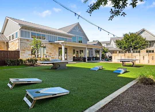 A backyard with a lawn and a building in the background.