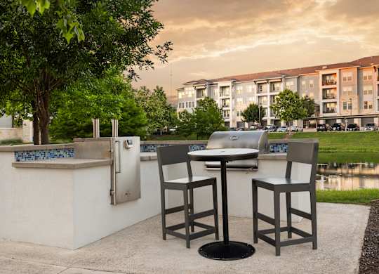 A table and two chairs are set up outside in front of a building.