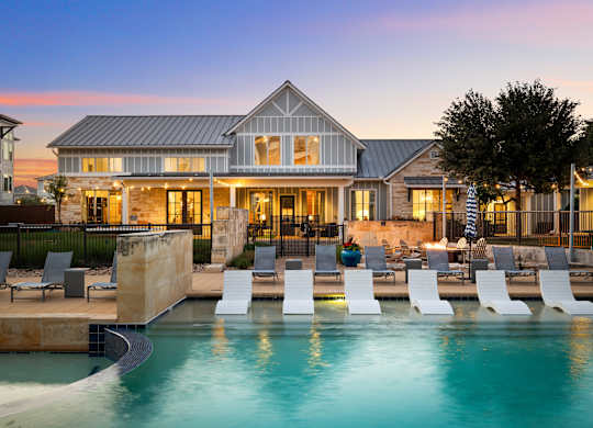 A large house with a pool in front of it.