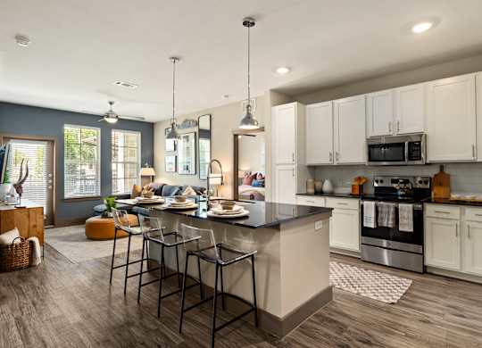 A modern kitchen with a large island and stainless steel appliances.