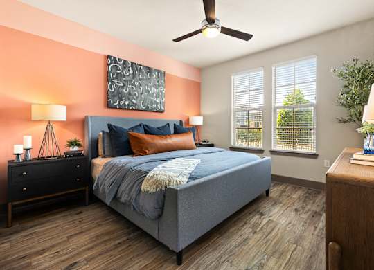 A bedroom with a bed, nightstands, and a ceiling fan.