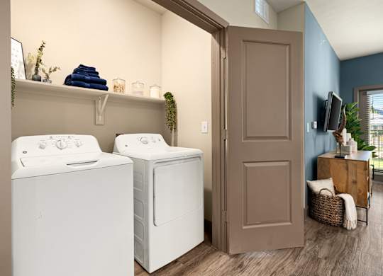 Two white front loading washing machines in a laundry room.