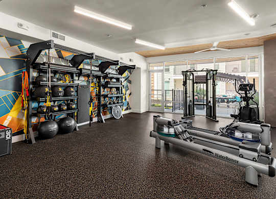 A gym with a variety of equipment including a rowing machine.