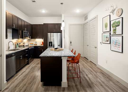 A kitchen with a table and chairs in the middle of the room.