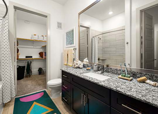 A bathroom with a sink, mirror, and toilet.