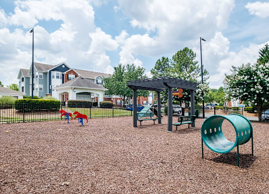 A playground with a green slide and a red and blue slide.
