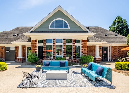 A house with a blue couch and a black chair in front of it.