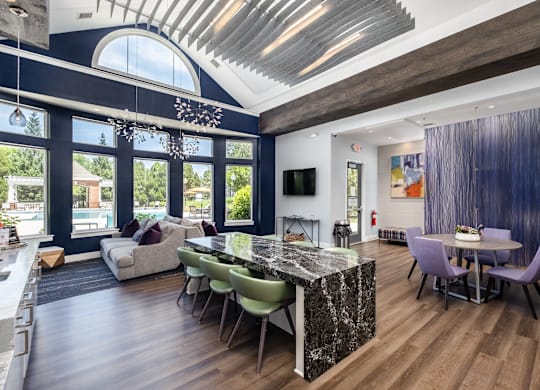 A modern kitchen with a marble island and a dining table set for four.