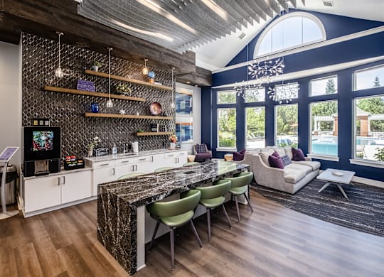 A kitchen with a marble countertop and a dining table with chairs.
