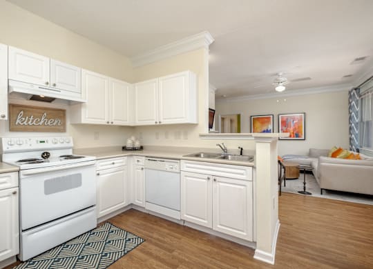 A kitchen with white cabinets and a white stove.