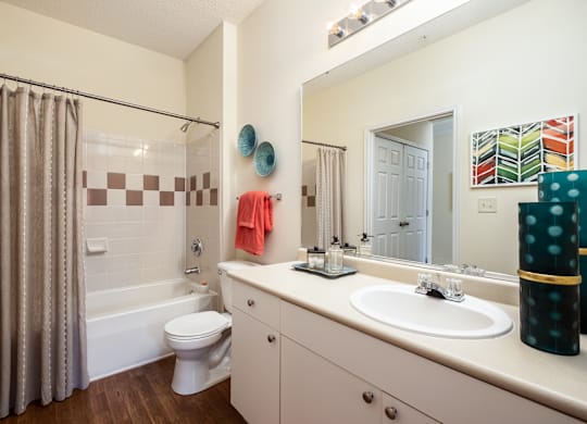 A bathroom with a white toilet, a white sink, and a white bathtub with a shower curtain.