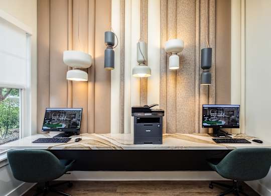 a desk with two computers and three monitors on it