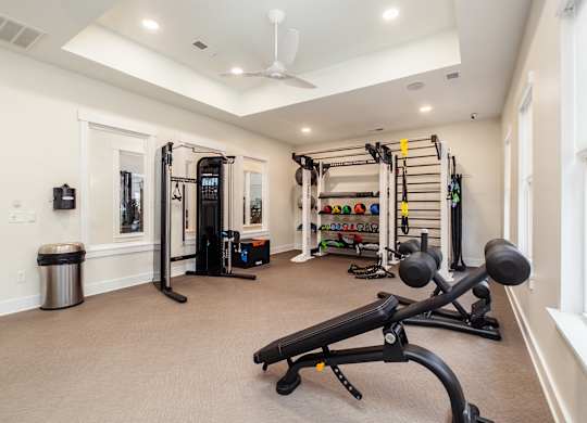 a home gym with exercise equipment and a ceiling fan