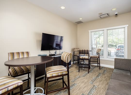 A living room with a television, chairs, and a couch.