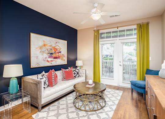 A living room with a white couch, a coffee table, and a painting on the wall.