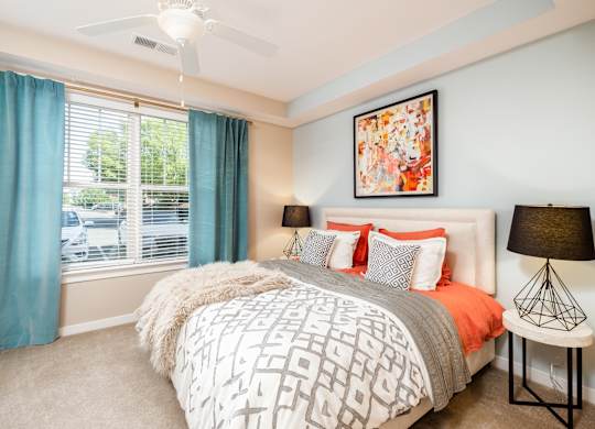 A bedroom with a large bed and a ceiling fan.