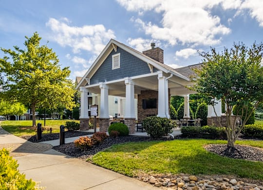 A blue house with white columns and a porch.