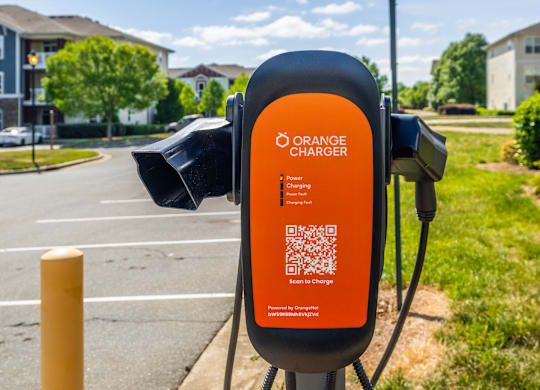 An Orange Charger station is located on the side of a road.