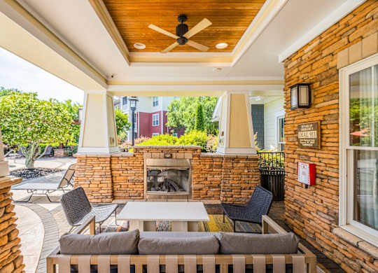 A patio with a brick fireplace and a white table.