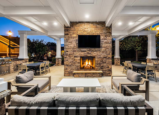 A patio with a fireplace and seating area.