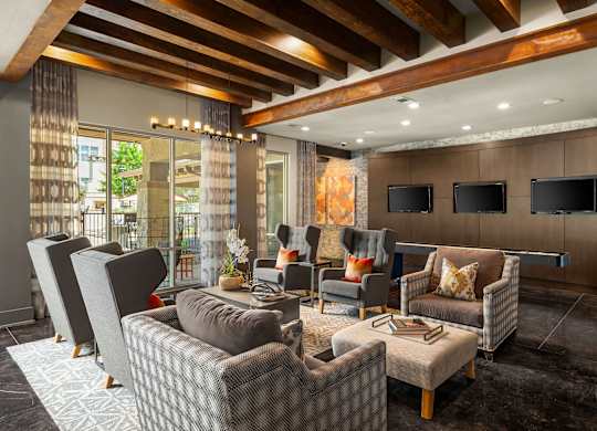 A living room with a grey sofa and a wooden ceiling.