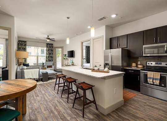 A modern kitchen with a wooden table and bar stools.