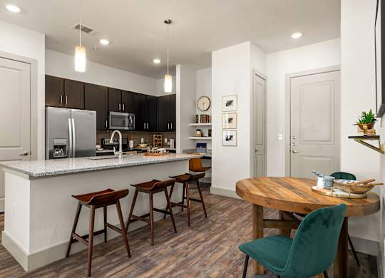 A kitchen with a white countertop and wooden floors.