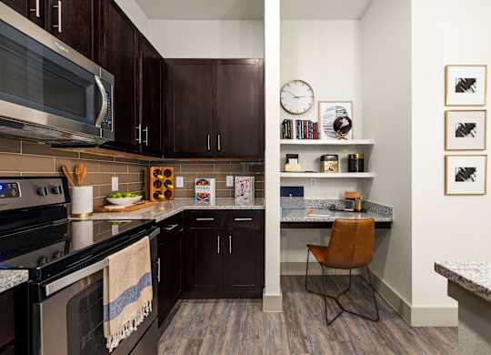 A kitchen with dark brown cabinets and a black stove top oven.