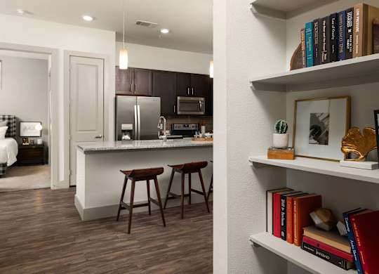 A kitchen with a white counter and brown bar stools.