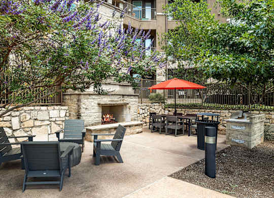 A patio with a fireplace and chairs.