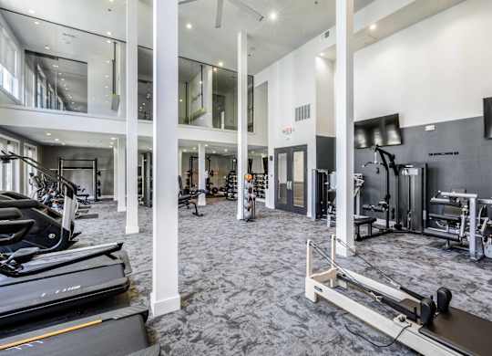 A gym with treadmills, weights, and exercise equipment.