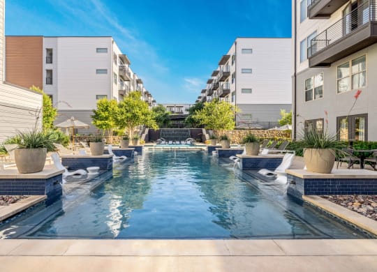 an apartment with a swimming pool in the middle of two buildings