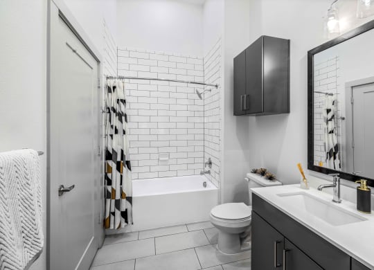 a white bathroom with a shower and a toilet and a sink