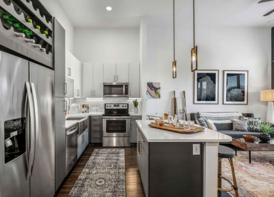an open kitchen and living room with stainless steel appliances