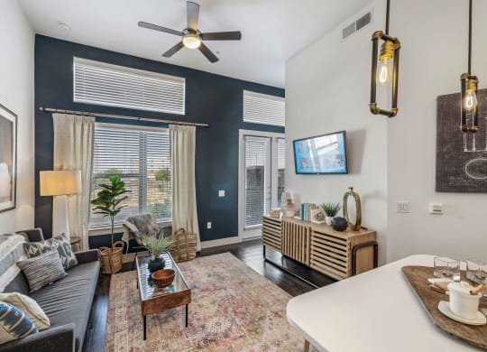 a living room with blue walls and a ceiling fan