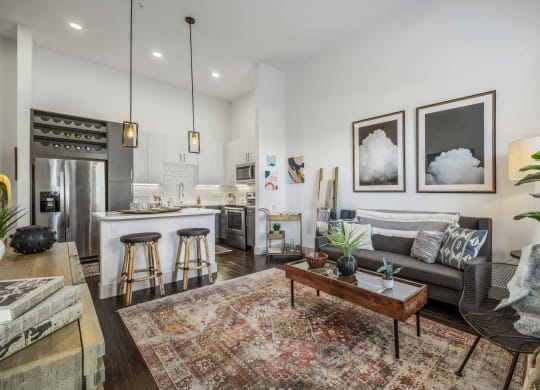 a living room with a couch and a kitchen with a bar