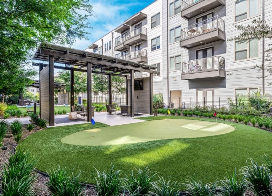 a putting green in front of an apartment building