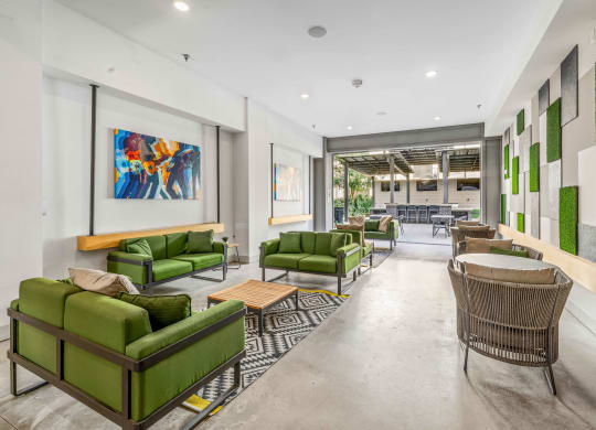 a living room with green couches and chairs and a table